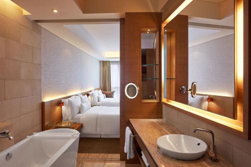 孟买孟买花园城威斯汀酒店的一间带床、水槽和浴缸的浴室