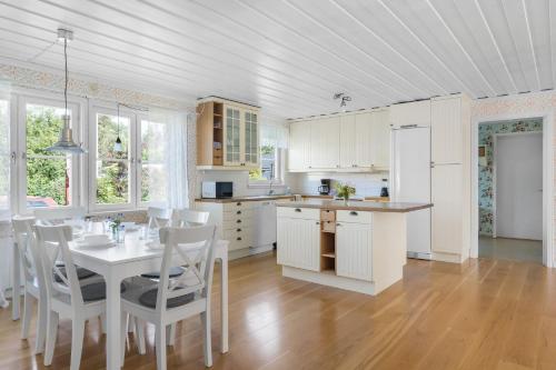 谢莱夫特奥Scenic Seaside Retreat near Northvolt Ett的厨房配有桌子、白色橱柜和桌椅