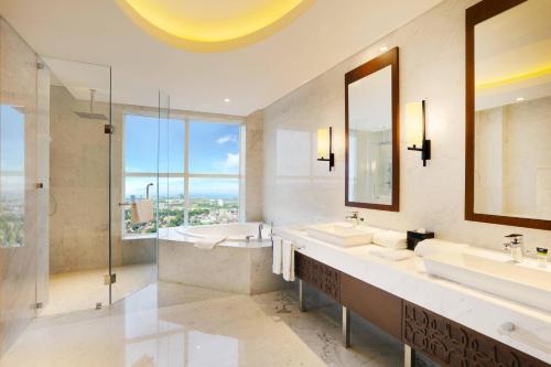 马卡萨望加锡福朋喜来登酒店的一间带两个盥洗盆的浴室和一个大窗户