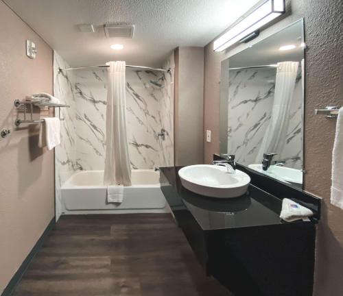 西萨克拉门托萨克拉门托市中心6号汽车旅馆的浴室配有盥洗盆和浴缸。