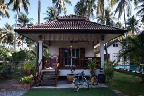 Ban Wa ThonCoconut Tree Homestay的一辆自行车停在房子前面