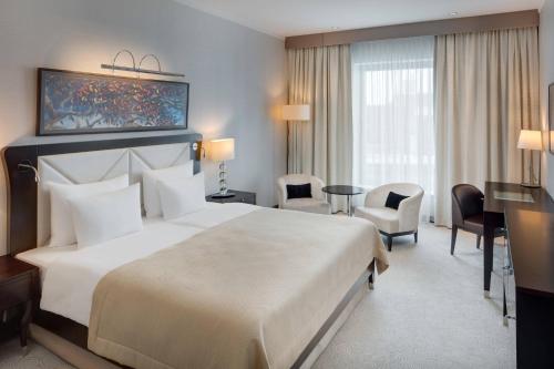 布拉迪斯拉发Grand Hotel River Park, a Luxury Collection Hotel, Bratislava的酒店客房设有一张大床和一张书桌。