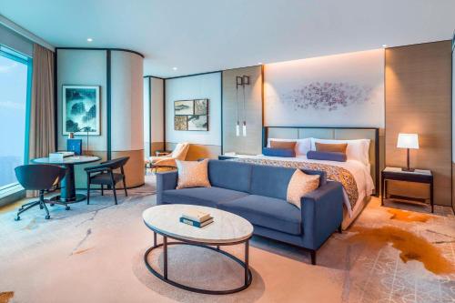 长沙长沙梅溪湖金茂豪华精选酒店的酒店客房,配有床和蓝色的沙发