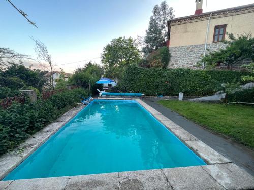 米拉弗洛迪拉希Casa independiente 4 habitaciones的一座大蓝色游泳池,位于房子前