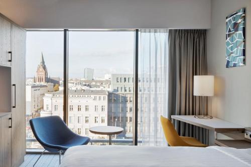 什切青Courtyard by Marriott Szczecin City的酒店客房设有一张床和一个大窗户
