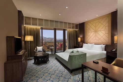 海得拉巴ITC Kohenur, a Luxury Collection Hotel, Hyderabad的酒店客房,配有床和电视