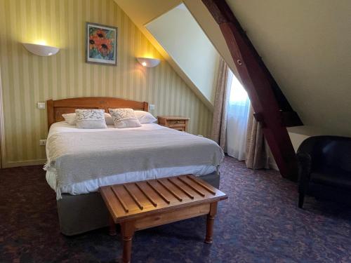 欧坦Logis Hôtel de la Tête Noire的一间卧室配有一张大床和一把椅子