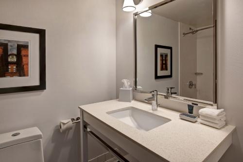 皮奥里亚Four Points by Sheraton Peoria的白色的浴室设有水槽和镜子