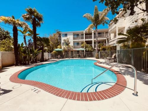 圣路易斯-奥比斯保Hotel Buena Vista - San Luis Obispo的棕榈树建筑前的游泳池