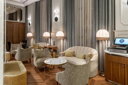 伊斯坦布尔Orientbank Hotel Istanbul, Autograph Collection的客厅配有椅子、沙发和电视
