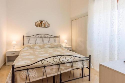 托雷圣乔万尼乌Villa Rosa zona Torre San Giovanni的一间卧室设有床、两张桌子和一扇窗户