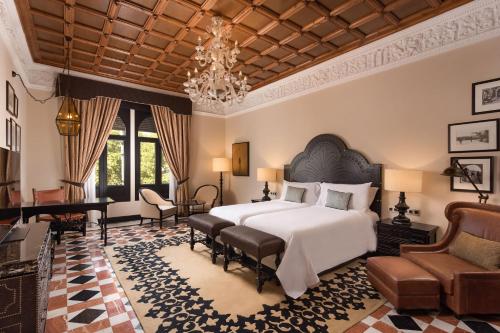 塞维利亚Hotel Alfonso XIII, a Luxury Collection Hotel, Seville的一间卧室配有一张大床和一个吊灯。