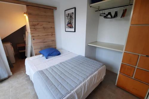 加桑Sunny Gassin的一间卧室配有一张带蓝色枕头的床