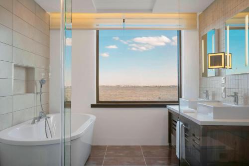 内罗毕内罗毕机场福朋喜来登酒店 的带浴缸、水槽和窗户的浴室