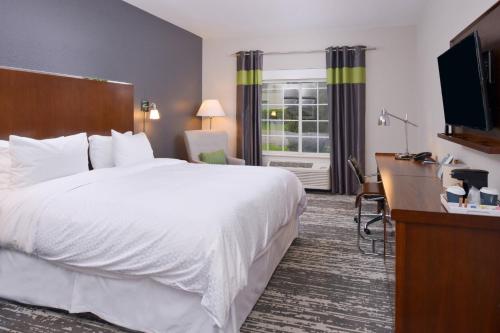 芒特普罗佩特芒特普罗斯佩克特奥黑尔福朋喜来登酒店的酒店客房设有一张白色大床和一张书桌