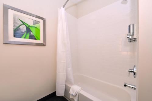 芒特普罗佩特芒特普罗斯佩克特奥黑尔福朋喜来登酒店的浴室配有白色浴缸和淋浴。