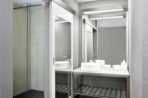 卡尔加里Aloft Hotel Calgary University的一间带两个盥洗盆和淋浴的浴室