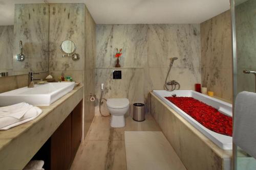 浦那Four Points by Sheraton Hotel and Serviced Apartments Pune的带浴缸、卫生间和盥洗盆的浴室