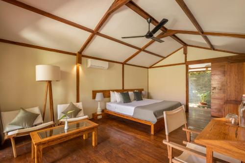 吉利特拉旺安Gili Teak Beach Front Resort的卧室配有一张床和一张桌子及椅子