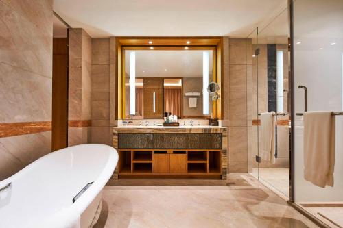 滁州滁州港汇喜来登酒店的带浴缸、水槽和镜子的浴室