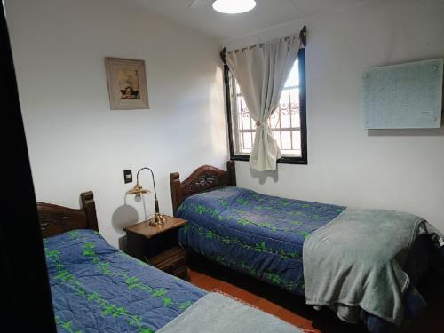 圣胡安Complejo Los Aromos, San Juan, AR的一间卧室设有两张床和窗户。