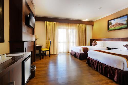 日惹皇家大摩玛丽欧波罗酒店的酒店客房配有两张床和一张书桌