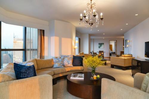 曼谷Tower Club at lebua的客厅配有沙发和桌子