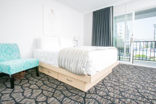 五月岬郡长春花旅馆的卧室配有床、椅子和窗户。