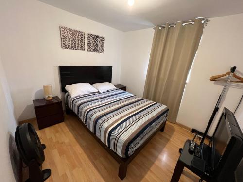 利马Lima Mini Aparts Monterrico - Cerca Embajada EEUU的一间卧室配有一张床和一台电视