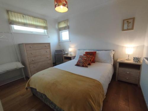 博格诺里吉斯Top of the House的一间卧室配有一张带2个床头柜和2盏灯的床。