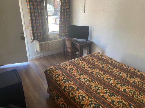 加伯维尔Johnston's Motel的一间卧室配有一张床和一张书桌及电视
