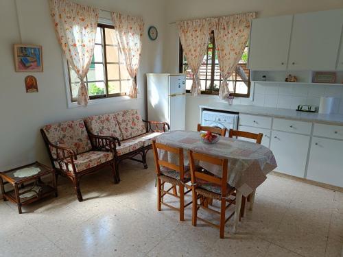帕福斯The Grapevine Guest House的厨房配有桌椅和沙发。