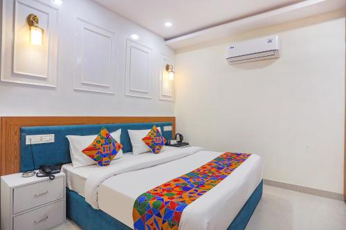 阿拉哈巴德FabHotel Cosmos的一间卧室配有一张带彩色毯子的床