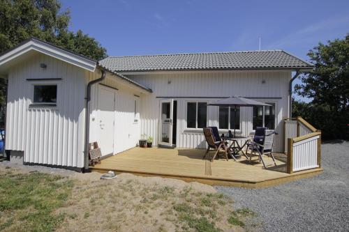 瓦尔贝里Fräsch nybyggd stuga på Getterön Varberg的房屋设有木甲板,配有桌椅