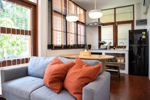清迈Ray's Home,3BR with front yard,walkable to Nimman的一间带蓝色沙发的客厅和一间厨房