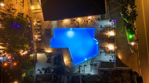 雷夫卡达镇塞米勒米斯酒店的夜间大楼中央的蓝色泳池
