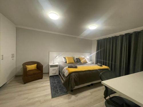 开普敦De Tuin Accommodation的一间卧室配有一张床和一把椅子