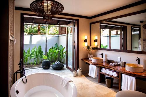 博瓦隆STORY Seychelles的一间带大浴缸和大窗户的浴室