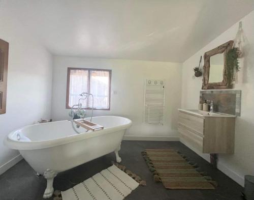 FuteauAu Bien Hêtre的白色的浴室设有浴缸和水槽。