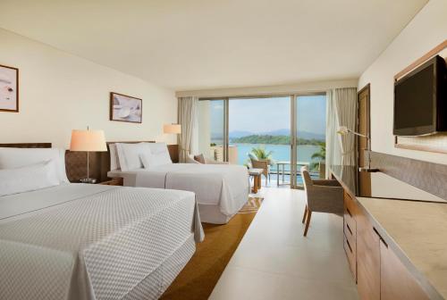 普吉镇The Westin Siray Bay Resort & Spa, Phuket的酒店客房设有两张床和一台平面电视。