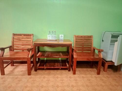 坤西育府บ้านนารีสอร์ท的两张椅子、一张木桌、一张桌子和两把椅子