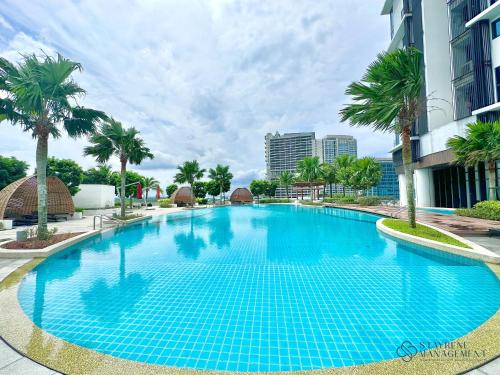 努沙再也Almas Suites Puteri Harbour by Stayrene的一座种植了棕榈树和建筑的大型蓝色游泳池