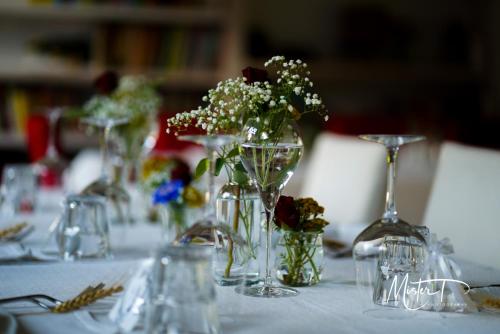 皮亚韦河畔诺文塔塞特桑托贝瑞农家乐的一张桌子,上面有几个花瓶,里面有鲜花