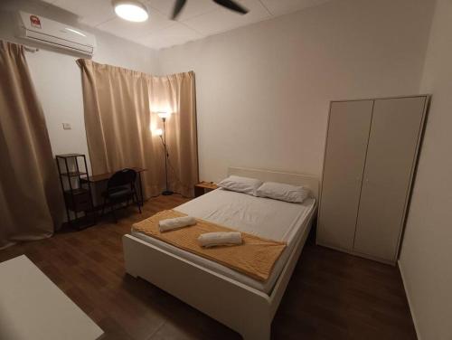 加影Tenang Retreat Holiday Home的一间卧室配有一张床,上面有两条毛巾