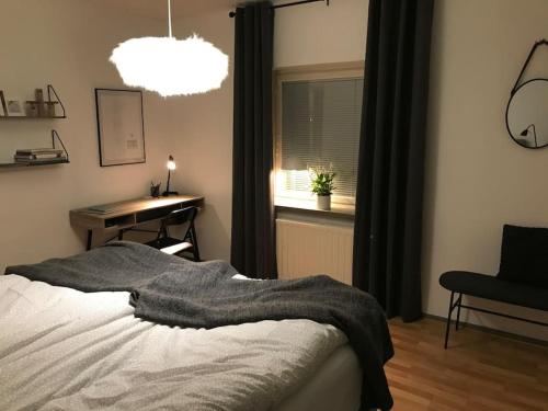 玛丽港Fräsch centrumlägenhet!的一间卧室配有一张床、一张书桌和一个窗户。