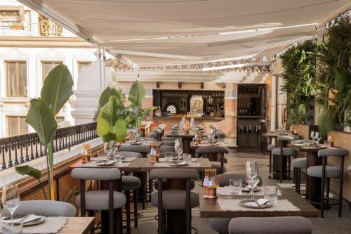 EsteponaHotel El Pilar Andalucia的一间设有桌椅的餐厅,种植了植物