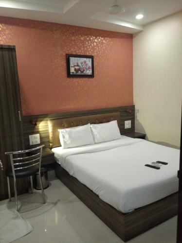 孟买Orange International-SANTACRUZ的一间卧室设有一张红色墙壁的大床