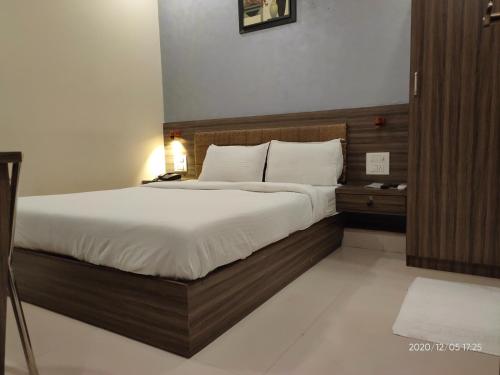 孟买Orange International-SANTACRUZ的一间卧室配有一张带白色床单的大床