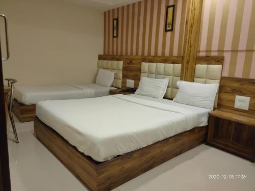 孟买Orange International-SANTACRUZ的一间卧室配有两张带白色床单的床
