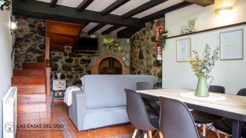 La Seronda de Villaorille - Las Casas del Oso的一间带桌子和沙发的用餐室